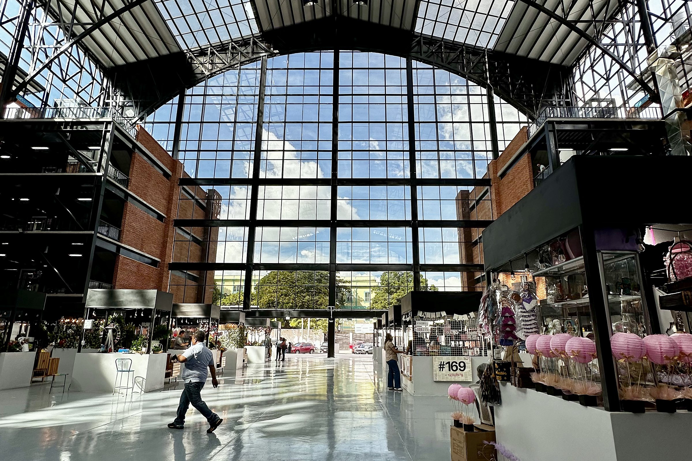 Compradores caminando por la nave luminosa y con techo de vidrio del nuevo Mercado San Miguelito en San Salvador